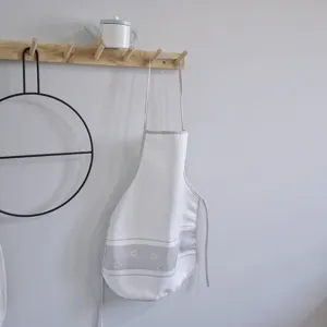 Children kitchen toy detail view showing wooden wall hook and cute white apron for kids play.