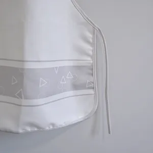 Minimalist grey and white geometric apron detail, featuring clean fabric and neat strap design.