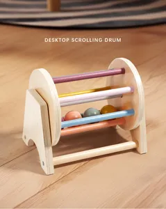 Close-up detail of the wooden rolling drum toy featuring colorful bars and small balls inside.