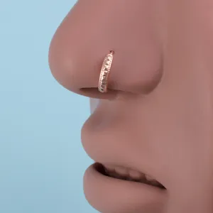 Close-up view of rose gold geometric nose ring detail, showing perfect piercing jewelry quality.