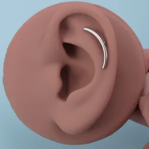 Detailaufnahme von Ohr-Piercing-Schmuck aus Edelstahl mit glänzender und glatter Metalloberfläche.