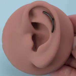 Detailaufnahme des eleganten schwarzen gebogenen Barbell Knorpel Piercings am Ohr-Modell