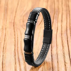 Black leather and metal bamboo bracelet close-up, punk style men jewelry detail view.