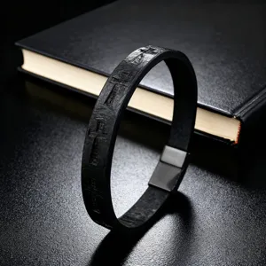 Close-up view of the black leather bracelet featuring embossed cross designs and clasp.