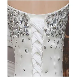 Close-up detail of white wedding dress back with lace-up corset and sparkling rhinestones.