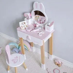 Vue détaillée de la coiffeuse pour enfants en bois avec miroir et accessoires dans une jolie pièce.