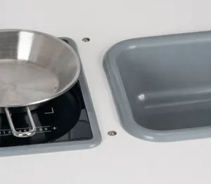Vista dettagliata della cucina giocattolo con piano cottura, padella in acciaio e lavandino.