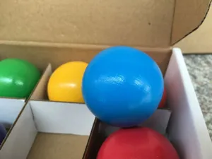 Close-up detail of colorful wooden balls toy in storage box, smooth surface for kids early learning.
