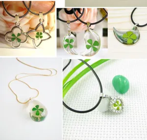 Close-up details of handmade real four-leaf clover resin pendant necklaces in various shapes.