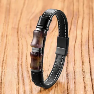Close-up detail of a retro black leather bracelet featuring stainless steel clasp and crystals.