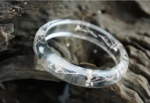 Clear resin dried flower bangle bracelet detail, handmade botanical jewelry accessory display.