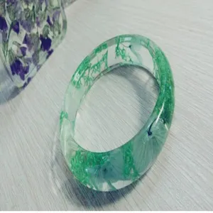 Handmade clear epoxy resin bracelet embedded with green moss and dried flowers for women daily wear.