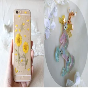Handmade epoxy resin craft showcasing a floral phone case and a glittery unicorn keychain.