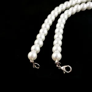 Detailopname van witte parelketting met zilveren karabijnsluiting voor DIY-accessoires.