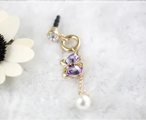 Detailopname van 3,5 mm stofplug met kristallen vlinder en elegante parelhanger.