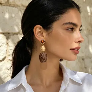 Detalle de pendientes de cuerda de cáñamo tejida con diseño geométrico y detalles de diamantes.