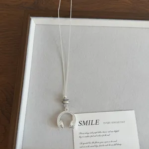 Lungo girocollo in argento con ciondolo a cuffia unico e decorazione di perle.