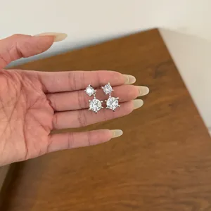 Close-up view of sparkling cubic zirconia double drop earrings, shining crystal detail.