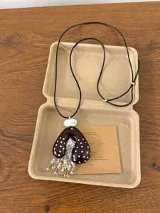 Retro Chinese style coconut shell necklace with beaded fringe and adjustable cord pendant.