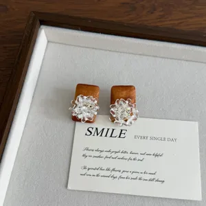 Detailed shot of retro wooden square earrings with exquisite crystal flower cluster studs.