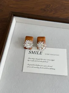 Close-up detail of retro wooden square earrings featuring sparkling crystal flower clusters on card.