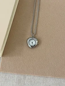 Vintage silver heart-shaped pocket watch pendant necklace, delicate detailed product view.