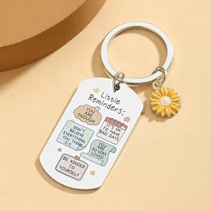 Stainless steel motivational keychain detail featuring UV printed reminder text and sunflower charm.