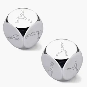 Stainless steel yoga dice detail showing laser-engraved fitness poses on shiny metallic surface.