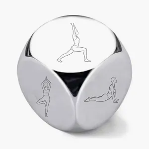 Close-up detail of the stainless steel yoga dice featuring engraved pose line art patterns.