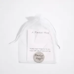 Stainless steel pocket hug token with card and white organza gift bag for loved ones.