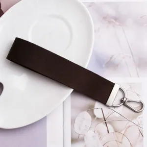 Solid color fabric wristlet strap with silver metal clasp keychain for car keys and bags.