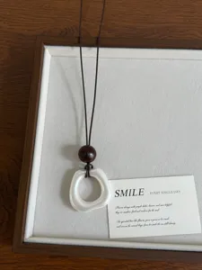 Nuova collana con ciondolo bianco perla stile cinese con perina di legno e corda marrone.