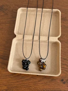 Detail view of natural stone grape beaded necklaces, featuring black and tiger eye pendant styles.