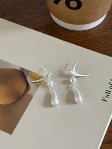Pendientes colgantes de ave y perla en plata mate, joyas de diseño de nicho único.