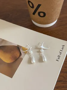 Exquisitos pendientes de perla y pájaro de plata mate, diseño de nicho único para mujeres.