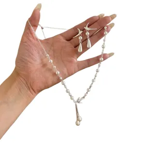 Elegante conjunto de collar y pendientes con colgante de borla de pájaro plateado mate