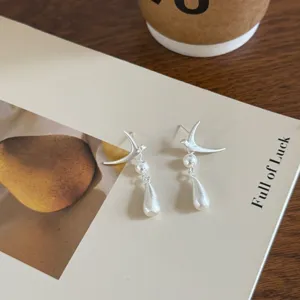 Pendientes de perlas de pájaro plateados, acabado mate, diseño elegante y chic.