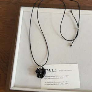 Chic black beaded grape pendant necklace with adjustable cord for autumn and winter fashion.