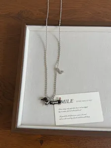 Close-up view of the vintage dachshund necklace featuring dripping oil pendant and cute heart charm.