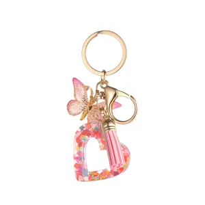 Joli porte-cles coeur en resine avec paillettes et pompon papillon pour vos sacs main.