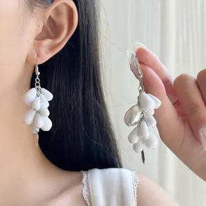 Pendientes largos de cuentas blancas, diseño de racimo con cadena plateada y dije elegante.