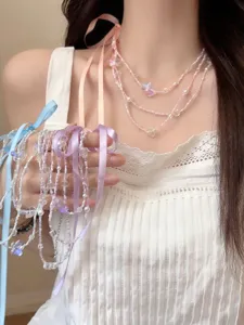Primo piano della collana di perle stile balletto multistrato con graziosi fiocchi.