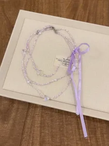 Collana di perle stile balletto con ciondoli a farfalla in cristallo e nastro viola.