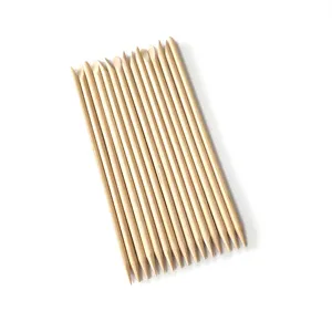 Close-up detail of natural wood cuticle pushers, smooth surface for professional nail art care.
