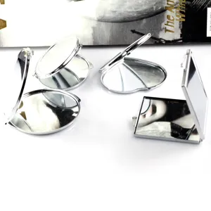 Silver metal folding compact mirror detail view showing various shapes and double sides.