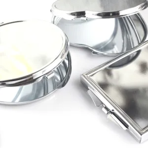 Close-up detail of silver stainless steel makeup mirrors, portable folding pocket mirror.