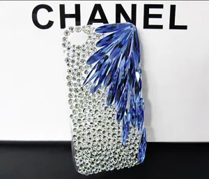 Close-up of sparkling rhinestone phone case with blue crystal wings DIY accessories details.