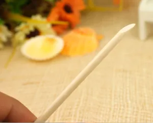 Detail view of natural wood cuticle pusher stick, perfect for nail art cleaning and dotting.