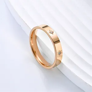 Close-up of rose gold titanium steel ring featuring sparkling crystal eight-pointed stars.