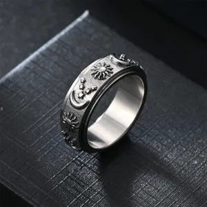 Dettaglio dell'anello antistress in acciaio inossidabile con incisioni di sole, luna e stelle.
